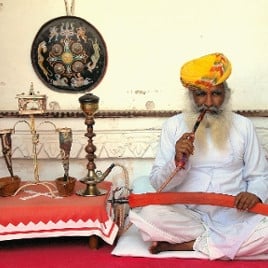 sitzender Inder mit Shisha am Opiumtisch
